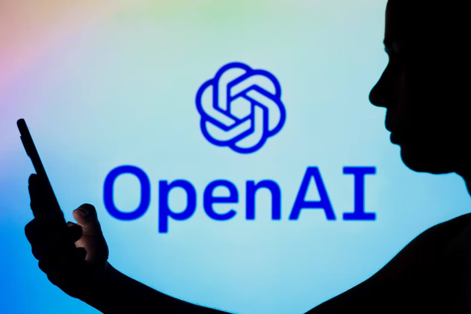 Logo di OpenAI con silhouette umana e smartphone, GPT-3 è realtà