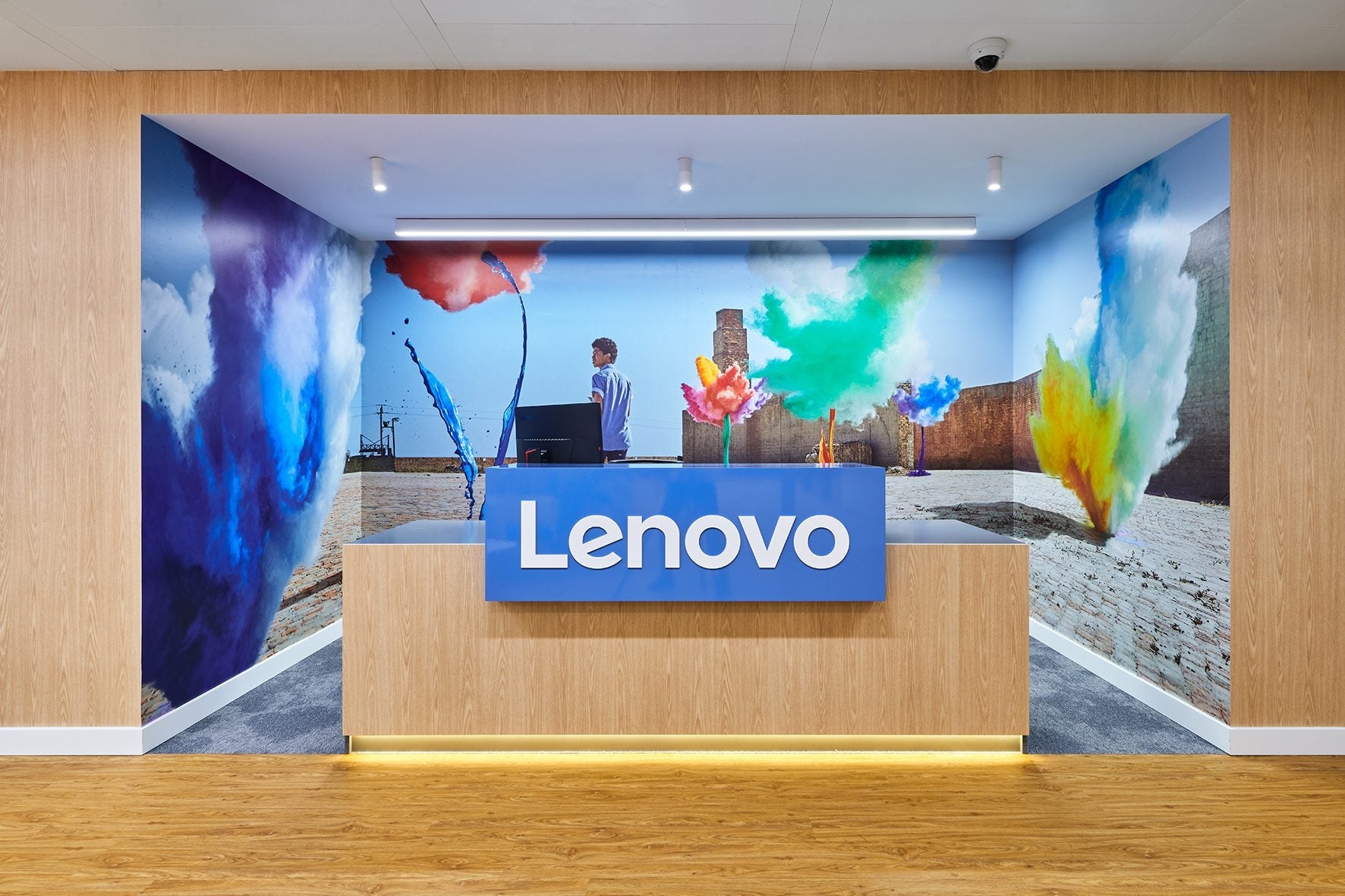 **Testo alternativo (alt text) in italiano:**
Reception Lenovo con logo su sfondo colorato e design moderno.