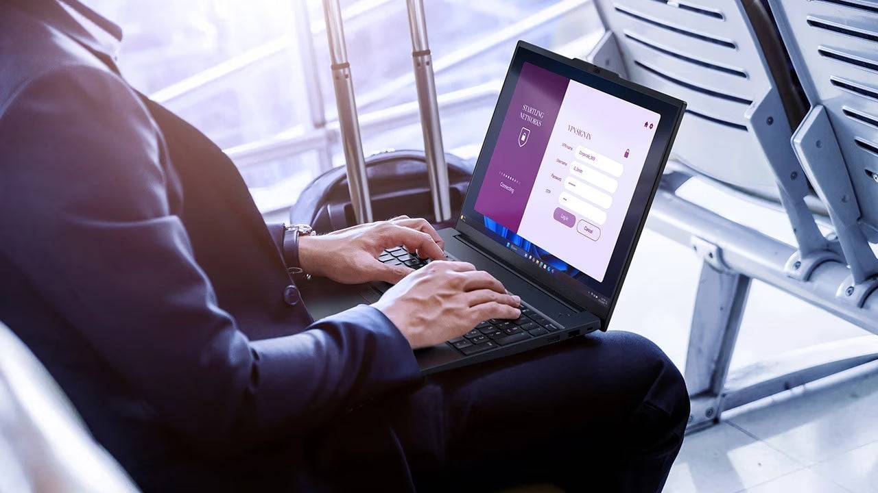 Uomo utilizza Lenovo ThinkPad E16 Gen 3 in aeroporto, notebook ideale per lavoro in mobilità grazie a prestazioni elevate e design portatile.