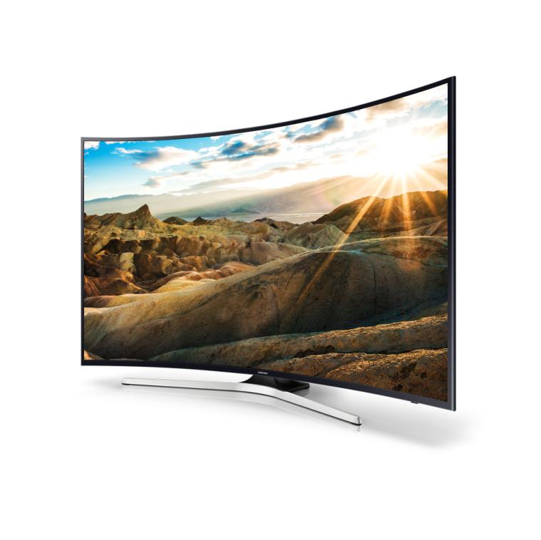 Televisore curvo UHD con paesaggio montano al tramonto sullo schermo.